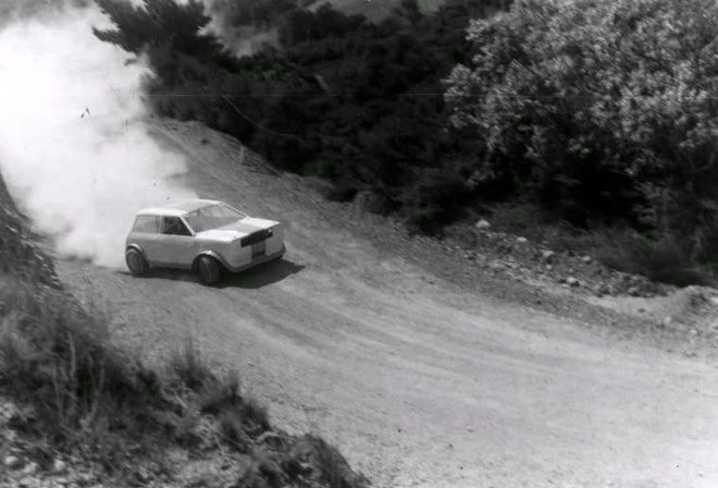 John Hocken in the white Mini Sprint throwing up dust on the gravel at Redwood Pass