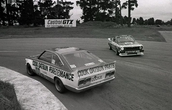 Reg Cook's Datsun from behind, COOKIE on the boot, chasing Aitken's #10 past a Castrol GTX sign
